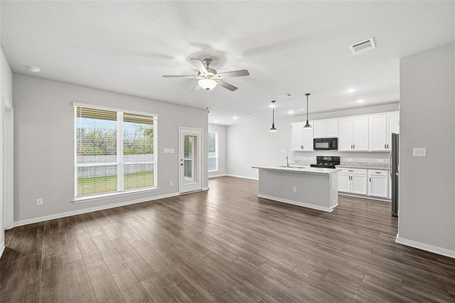 Unfurnished living room with dark wood-type flooring, a ceiling fan, and recessed lighting