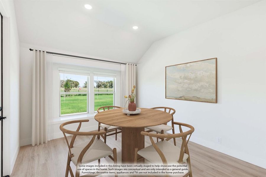 Dining area with round wood table, four chairs, vaulted ceiling, and window overlooking green yard