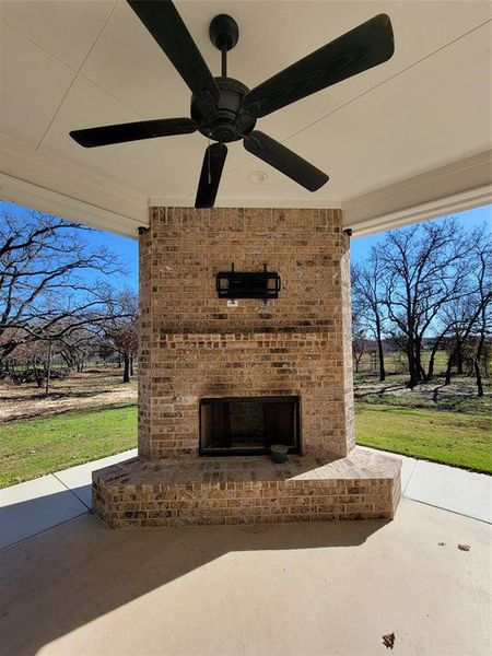 View of patio / terrace with an outdoor brick fireplace and ceiling fan