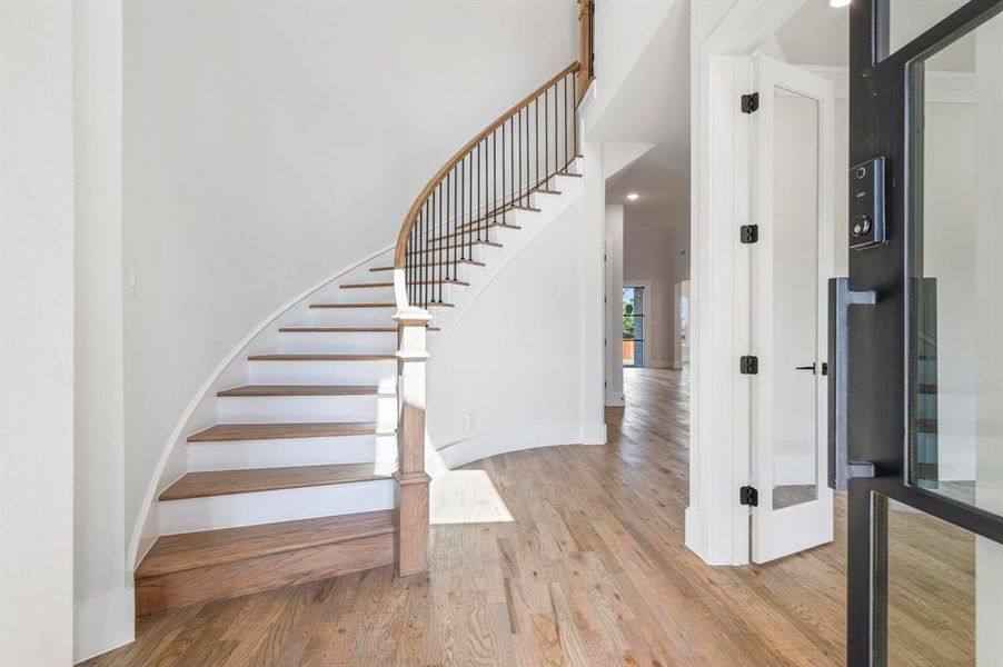 Stairs featuring hardwood / wood-style flooring