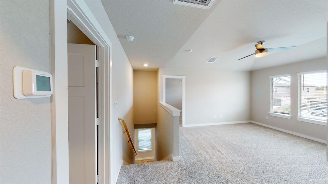 Empty room with healthy amount of natural light, ceiling fan, light carpet, and recessed lighting
