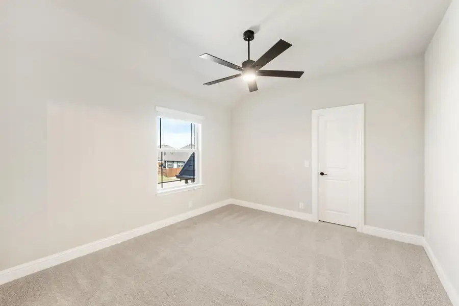Empty bedroom with vaulted ceiling, ceiling fan, carpet flooring, and single window