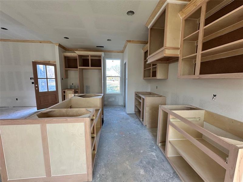 Kitchen with light brown cabinets, a healthy amount of sunlight, and ornamental molding