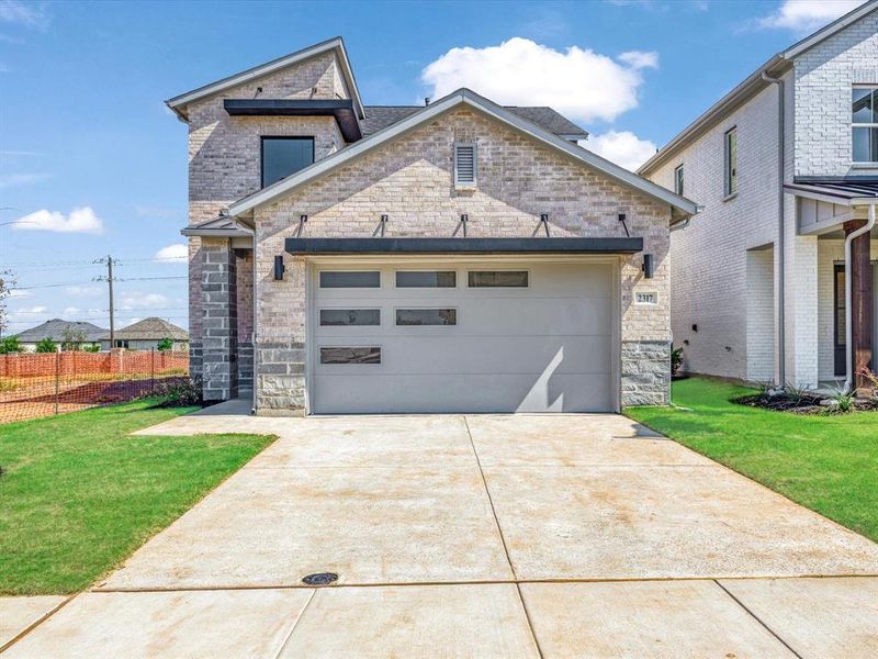 View of front of house with an attached garage, concrete driveway, and stone siding View of front of house with an attached garage, concrete driveway, and stone siding