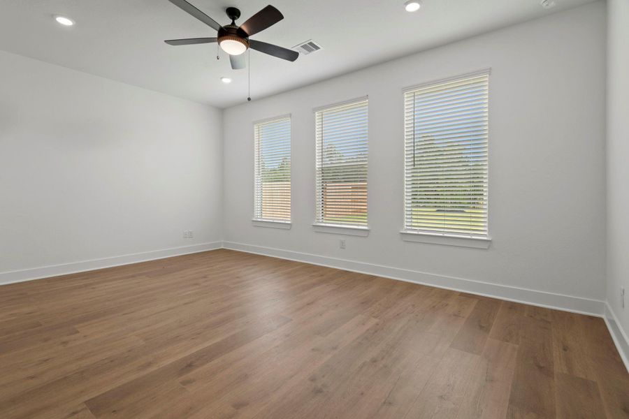The spacious master bedroom with luxury flooring, located downstiars.