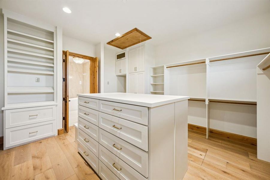Walk in closet featuring light wood finished floors and attic access