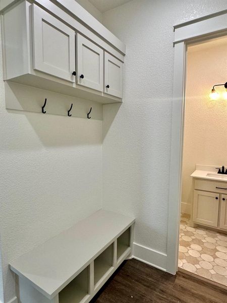 Mudroom with a textured wall and dark wood-type flooring