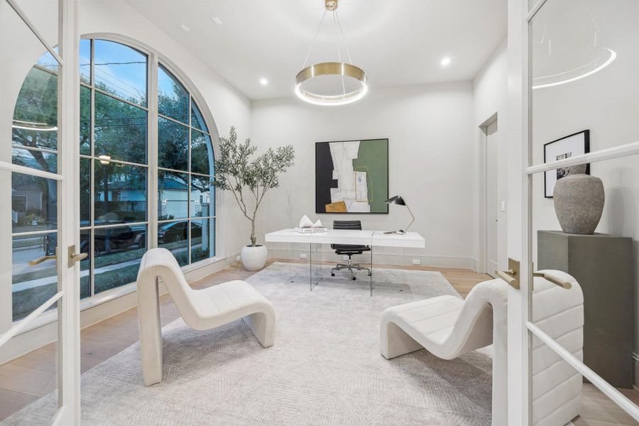 [Home Office] A light-filled home office with French doors. window overlooking front gardens, and creating a private and polished workspace. May also be used as a formal living room.