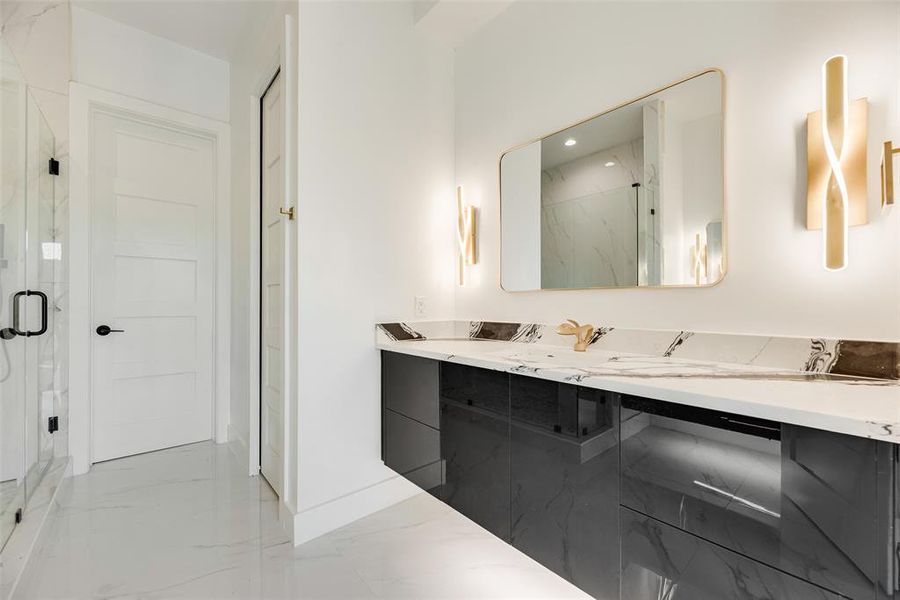 Full bath featuring light marble finish floors, double vanity, a marble finish shower, and recessed lighting Full bath featuring light marble finish floors, double vanity, a marble finish shower, and recessed lighting
