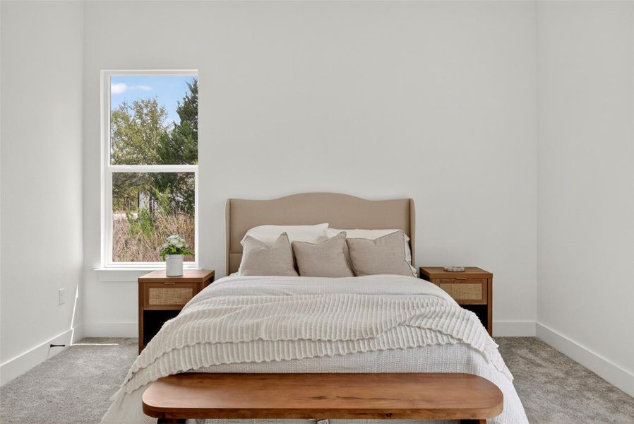 Bedroom featuring light colored carpet and baseboards