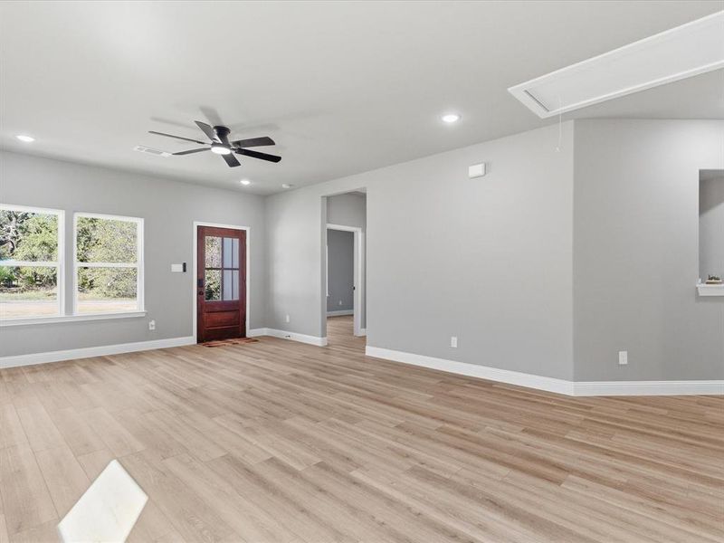 Unfurnished living room featuring light wood-type flooring, attic access, recessed lighting, and ceiling fan Unfurnished living room featuring light wood-type flooring, attic access, recessed lighting, and ceiling fan
