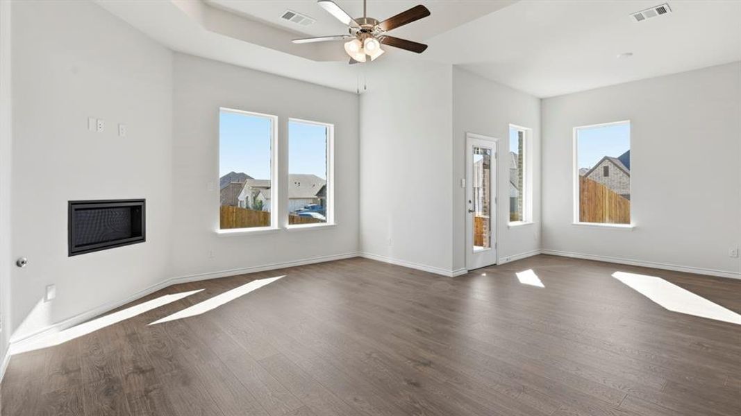 Unfurnished living room with dark wood-style floors and ceiling fan Unfurnished living room with dark wood-style floors and ceiling fan