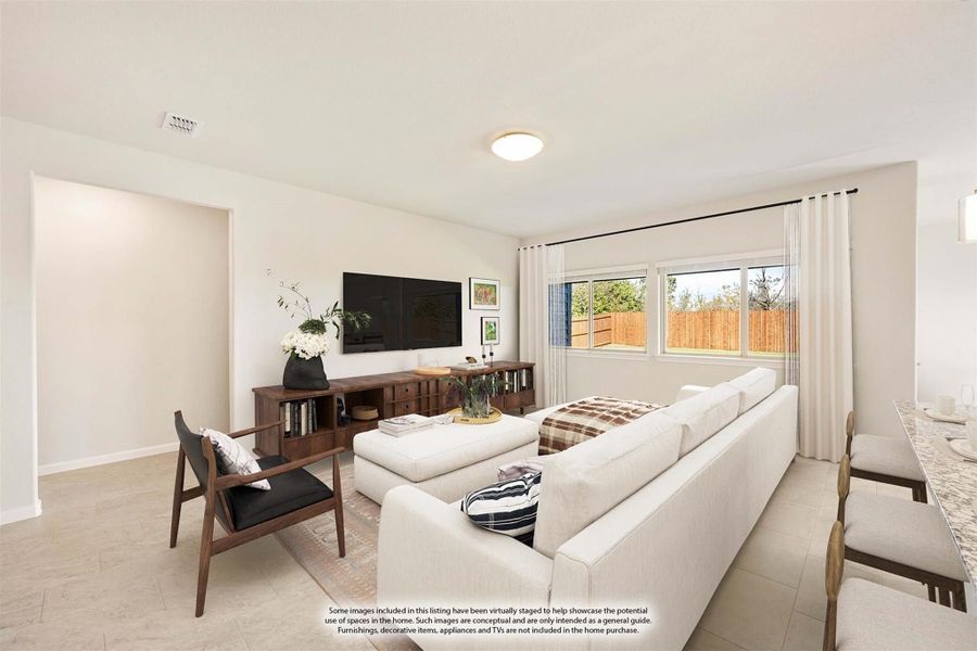 Bright living room with white sectional sofa, wall-mounted TV, and large window with backyard view