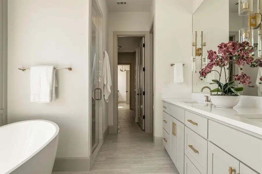 Full bath with double vanity, a shower stall, and a freestanding bath