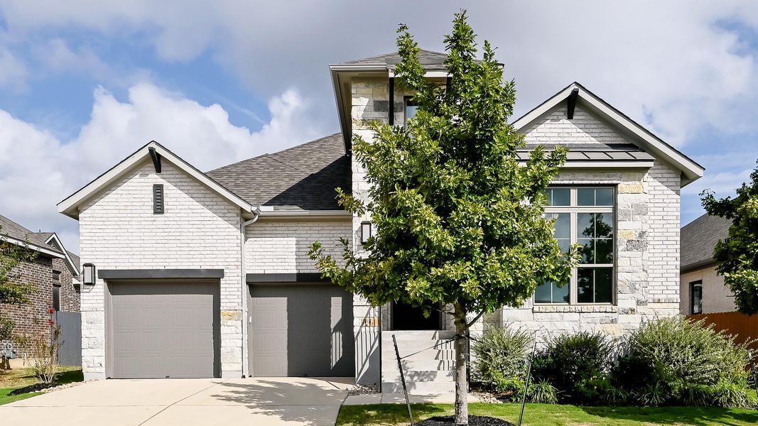 View of front of house featuring stone siding, a shingled roof, driveway, and a standing seam roof View of front of house featuring stone siding, a shingled roof, driveway, and a standing seam roof
