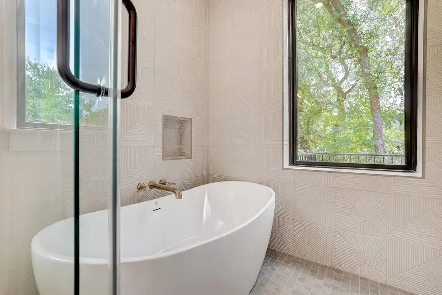 Full bath with a freestanding tub and tile walls