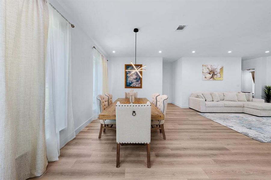 Dining room with light wood-style floors and recessed lighting Dining room with light wood-style floors and recessed lighting