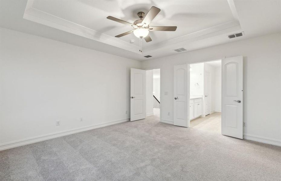 Spacious owner's suite highlighted by large windows and an exquisite tray ceiling *Real home pictured