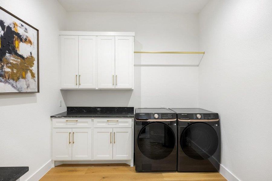 A well-appointed laundry room features ample cabinetry and a convenient hanging rod. A well-appointed laundry room features ample cabinetry and a convenient hanging rod.
