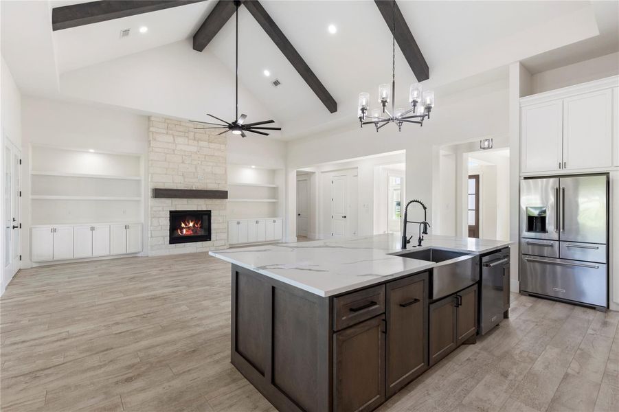 Extraordinarily high cathedral ceilings with wooden beams. Quartz countertops on an oversized kitchen island. A stone wall, wooden mantel with gas fireplace, and built-in cabinets offer a great space for the family. Extraordinarily high cathedral ceilings with wooden beams. Quartz countertops on an oversized kitchen island. A stone wall, wooden mantel with gas fireplace, and built-in cabinets offer a great space for the family.
