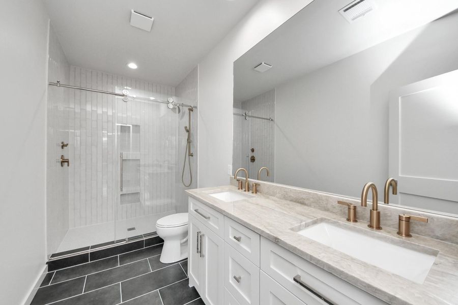 Designed as your private retreat, the spacious primary bathroom features dual vanities, premium stone countertops, designer fixtures, and a frameless glass walk-in shower with built-in niches—bringing everyday luxury and functionality together.