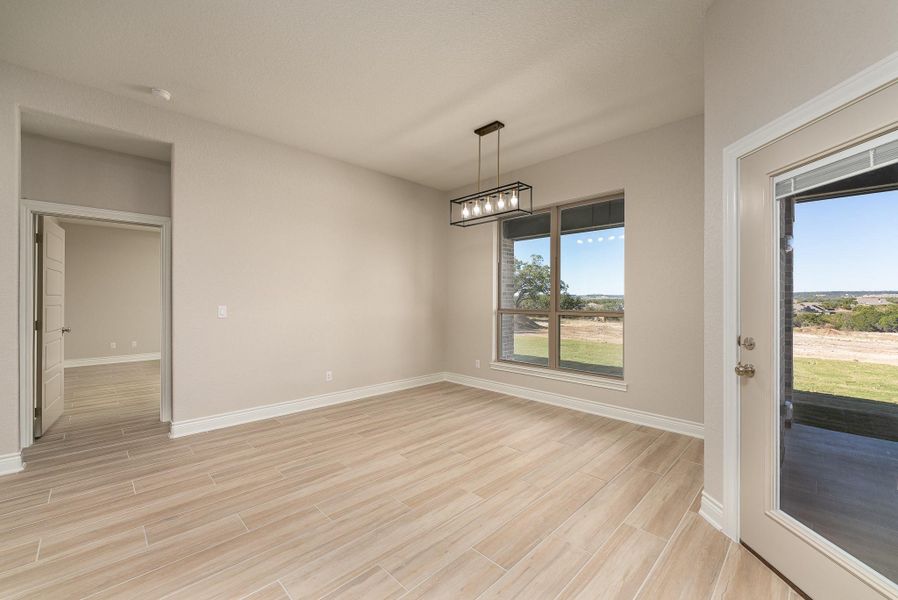 Unfurnished dining area featuring wood finish floors and a chandelier Unfurnished dining area featuring wood finish floors and a chandelier