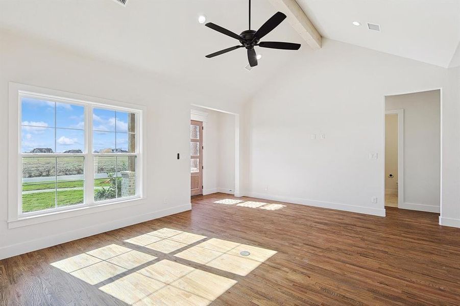 Unfurnished living room with beam ceiling, wood-type flooring, high vaulted ceiling, and ceiling fan