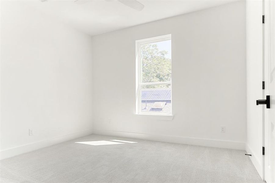 Carpeted empty room featuring ceiling fan