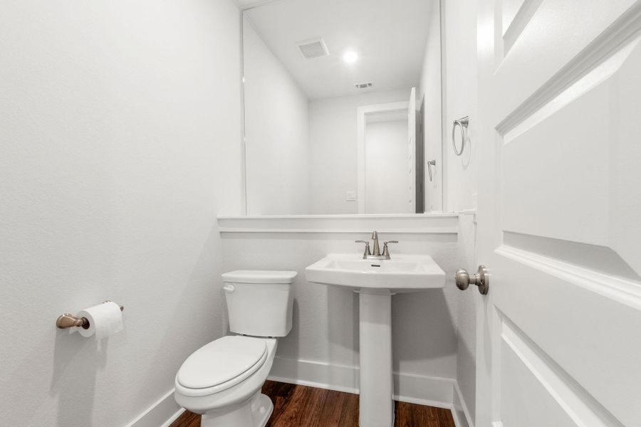 Bathroom featuring toilet, wood finished floors, baseboards, and a sink Bathroom featuring toilet, wood finished floors, baseboards, and a sink