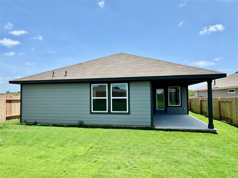 Rear view of house featuring a fenced backyard, a patio area, and roof with shingles