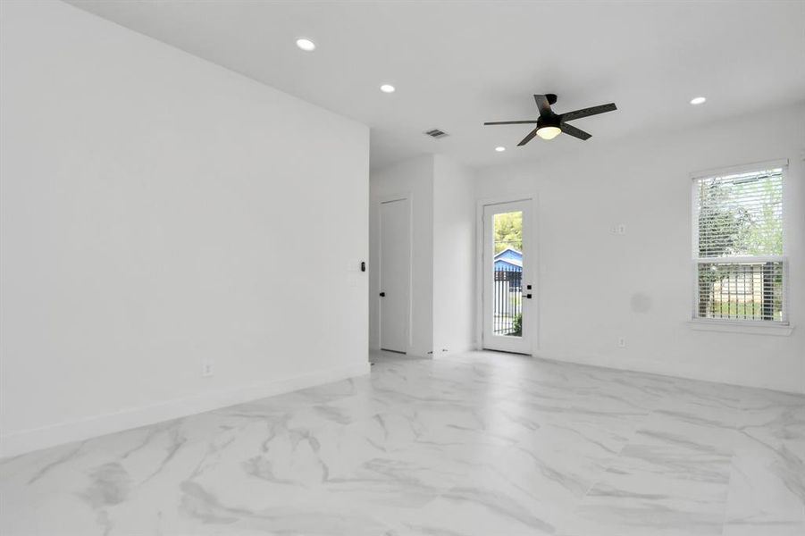 Revel in the contemporary charm of this spacious living area, accentuated by sleek tiled flooring and an open floor plan with an abundance of natural light.