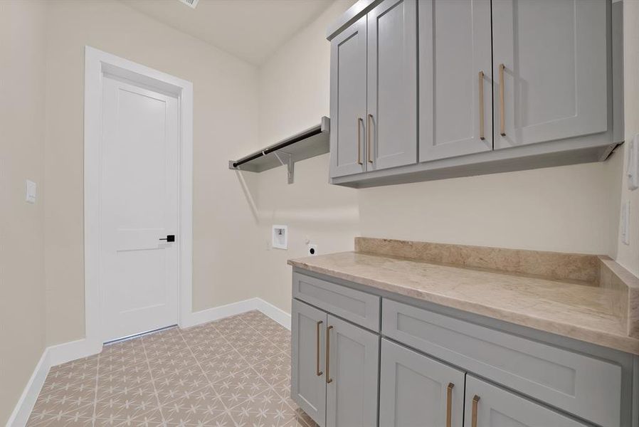 Washroom with hookup for a washing machine, cabinet space, light flooring, and hookup for an electric dryer Washroom with hookup for a washing machine, cabinet space, light flooring, and hookup for an electric dryer