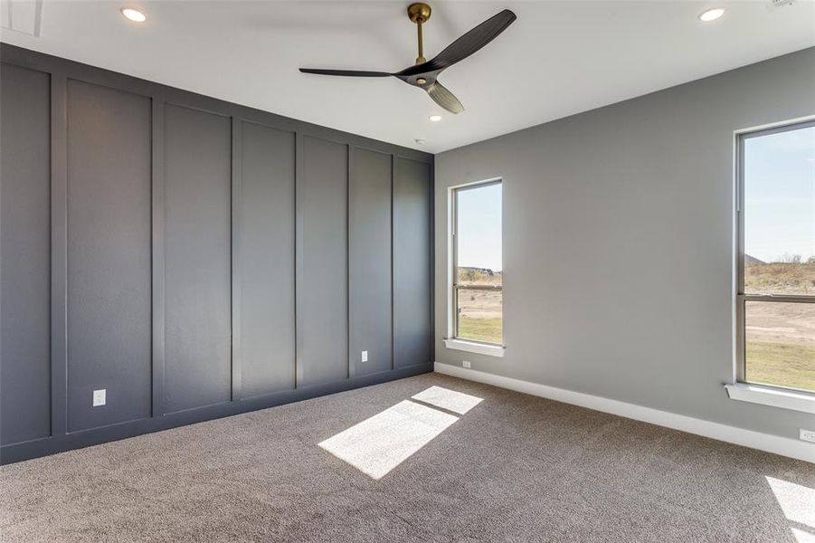 Unfurnished bedroom with a decorative wall, carpet floors, recessed lighting, and ceiling fan Unfurnished bedroom with a decorative wall, carpet floors, recessed lighting, and ceiling fan
