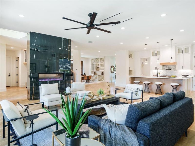 Living room with light wood-style floors, ceiling fan, and recessed lighting