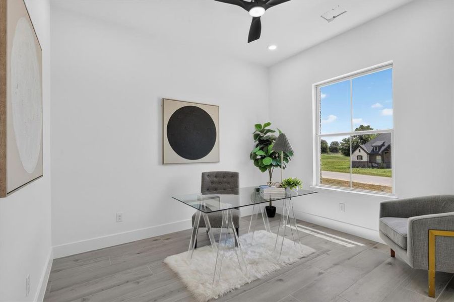 Bright room featuring a large window, light wood-finish flooring, recessed lighting, and a ceiling fan