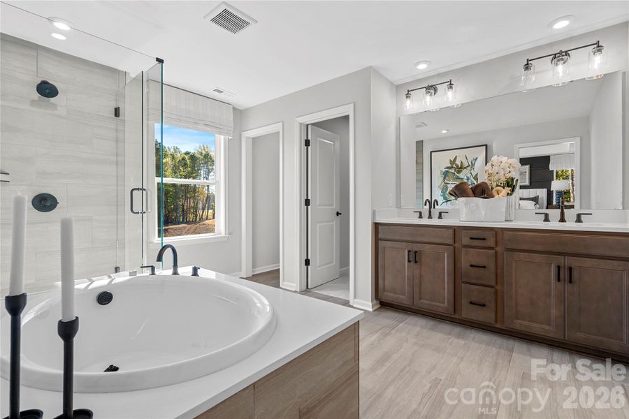 Garden tub, dual vanity, and walk-in shower make up this space. Garden tub, dual vanity, and walk-in shower make up this space.