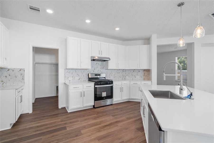 This kitchen is by far any chef’s dream! This spacious kitchen features high ceilings, stained wood cabinets, silestone countertops, SS appliances, modern tile backsplash, recessed and pendant lighting, extended counter space, silestone kitchen island single sink and space for breakfast bar, and a walk-in pantry all overlooking your huge family room.