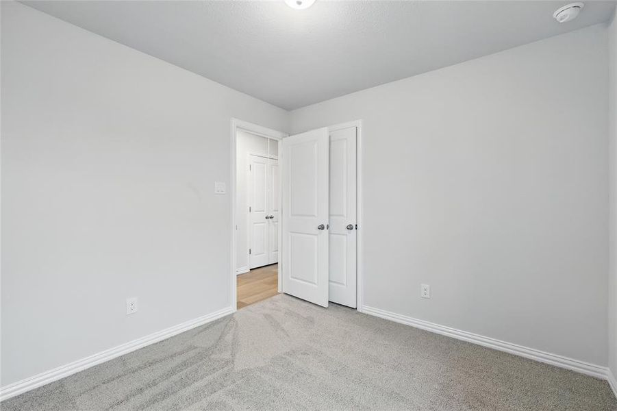 Carpeted empty room with baseboards