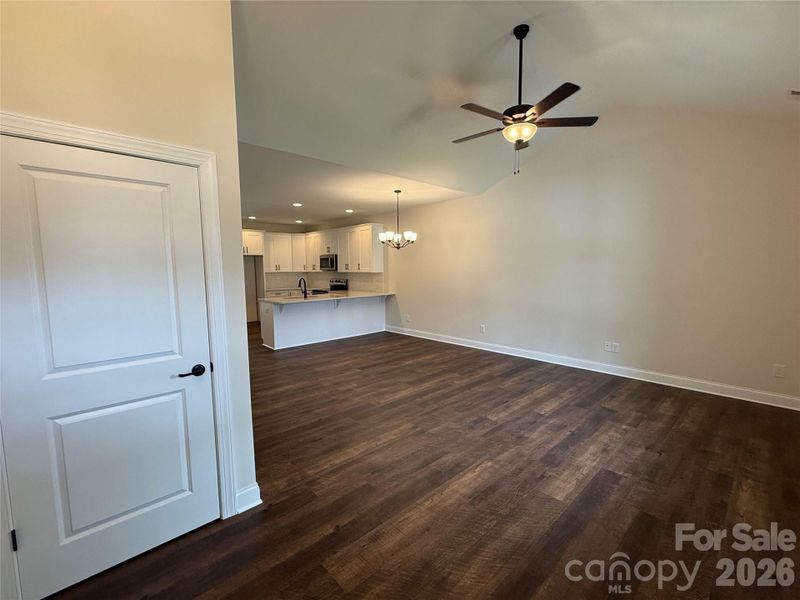 A large family room with vaulted ceiling, luxury vinyl plank flooring, and open floor plan greet you upon entry.
