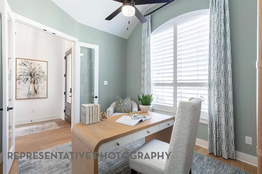 Office area with light wood-style flooring, french doors, ceiling fan, and lofted ceiling