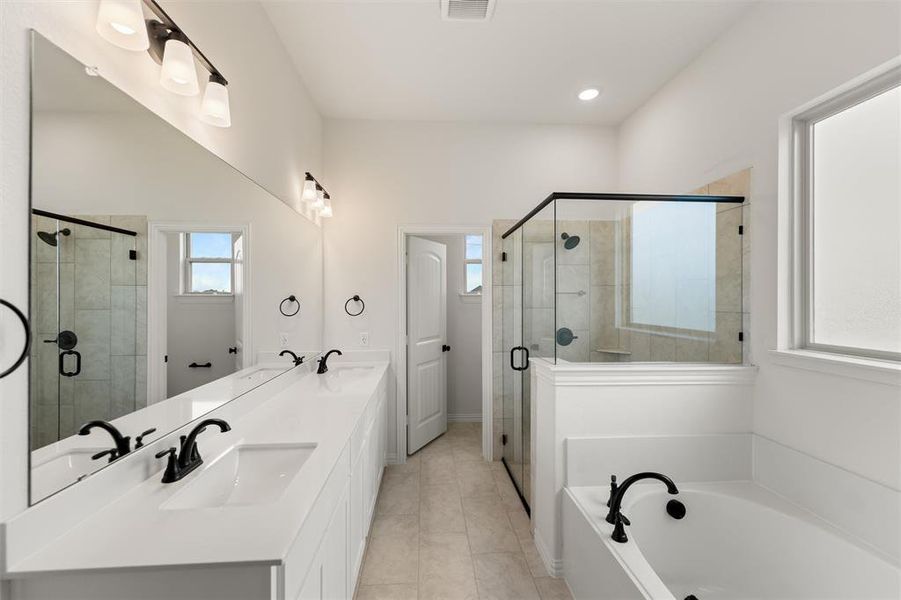 Full bathroom featuring double vanity, a stall shower, a bath, and recessed lighting