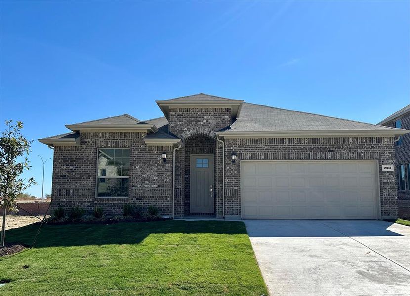 View of front of house featuring a front yard and a garage