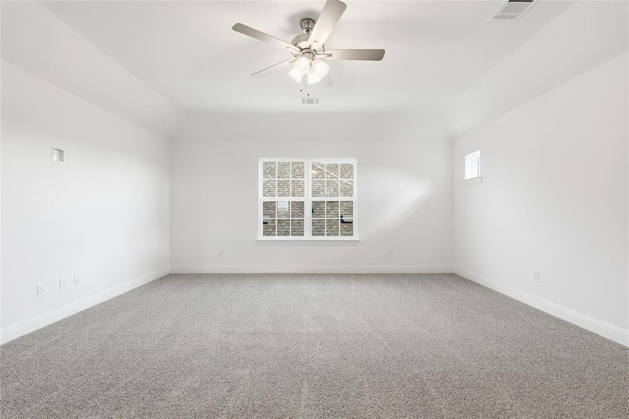 Unfurnished room with healthy amount of natural light, light colored carpet, and a ceiling fan Unfurnished room with healthy amount of natural light, light colored carpet, and a ceiling fan