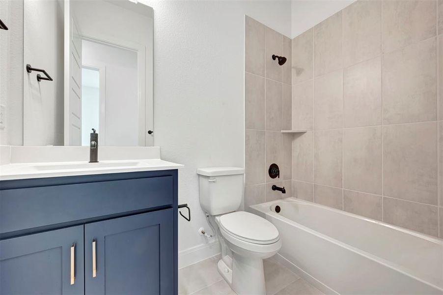 Bathroom featuring vanity, shower / bath combination, and light tile patterned floors Bathroom featuring vanity, shower / bath combination, and light tile patterned floors