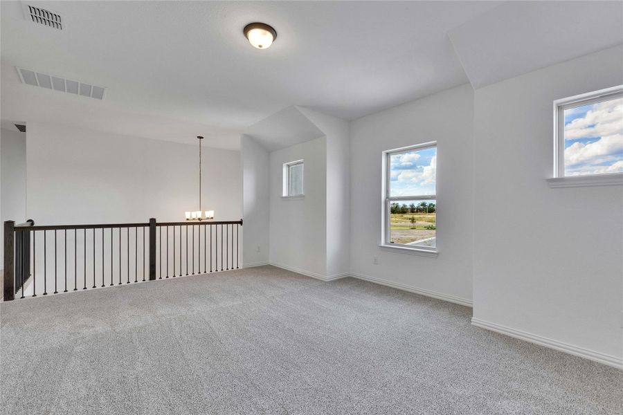 Unfurnished room featuring light carpet and a chandelier Unfurnished room featuring light carpet and a chandelier