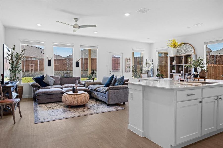 Spacious & open living area with LVP flooring, ceiling fan, and recessed lighting Spacious & open living area with LVP flooring, ceiling fan, and recessed lighting