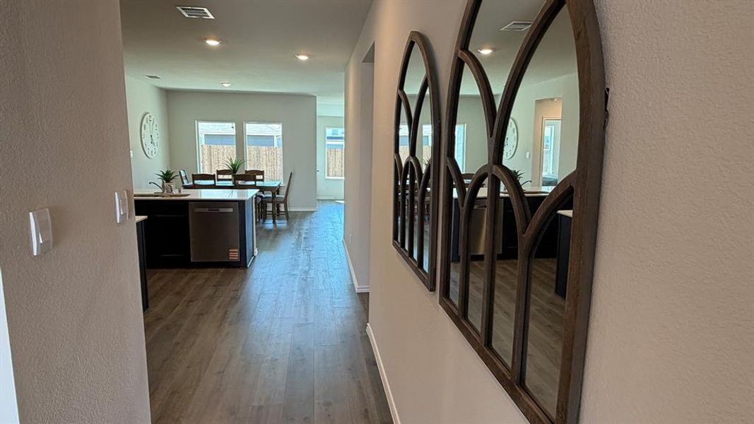 Corridor featuring a textured wall, dark wood-style flooring, and recessed lighting