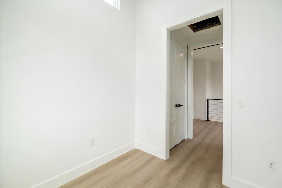 Corridor with light wood-style floors and baseboards