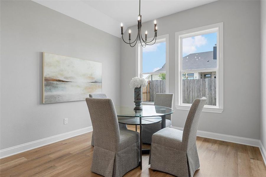Dining space featuring light wood-style floors and a chandelier Dining space featuring light wood-style floors and a chandelier