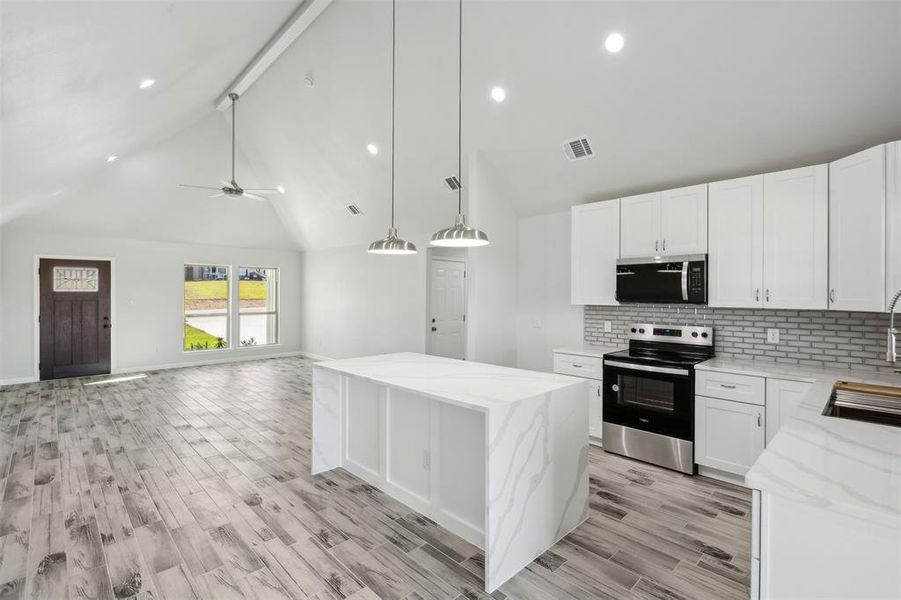 Kitchen featuring appliances with stainless steel finishes, white cabinetry, ceiling fan, and pendant lighting